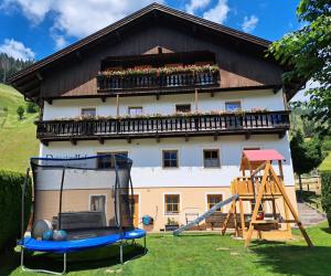 a house with a playground in front of it at Prünsterhof in Obertilliach