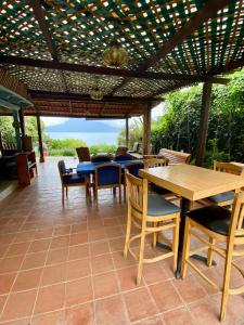 a patio with tables and chairs under a pergola at Lake Front Retreat at Los Elementos in Santa Cruz La Laguna