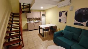 a living room with a couch and a table and a kitchen at Playamar Bungalows in Playa del Ingles