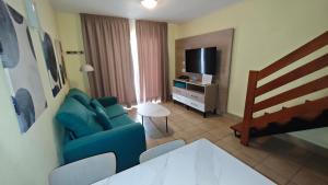 a living room with a blue couch and a television at Playamar Bungalows in Playa del Ingles