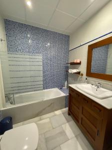 a bathroom with a tub and a sink and a toilet at Apartment Palacio de Los Vibora Parking Gratis in Lucena +23 photos