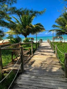 a wooden pathway to the beach with palm trees at Pousada Villa Bougainville Maragogi in Maragogi