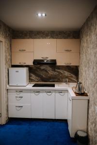 a kitchen with white cabinets and a blue floor at Avenue Nizami hotel in Baku