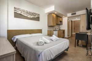 a hotel room with a bed and a kitchen at Marina Beach Apartaments - Sea views in the heart of Lloret in Lloret de Mar