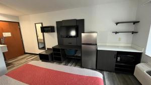 a room with a kitchen with a refrigerator and a counter at Studio 6 Suites Urbana, IL in Urbana