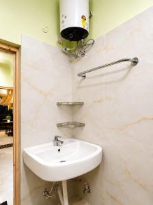 a white sink in a bathroom with marble walls at R S Homestay in Deoghar +4 photos