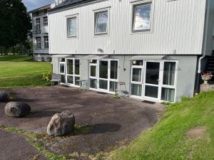a white house with windows and rocks in front of it at The Old Garages in Uddeholm