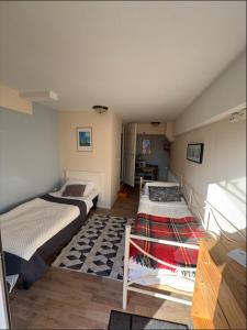 a room with two beds and a rug at The Old Garages in Uddeholm +4 photos