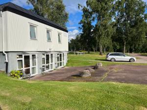 a car parked in front of a white house at The Old Garages in Uddeholm