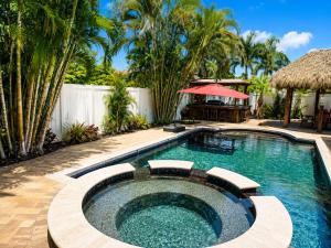 a swimming pool in a backyard with palm trees at Tropical Oasis 10th in Bradenton
