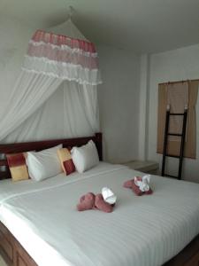 two stuffed animals are sitting on a bed at THAMONWAN hostel in Cha Am