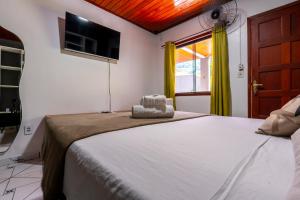 a bedroom with a large bed and a window at BLUE DOOR BRASIL in Abraão