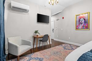 a room with a chair and a table and a television at The Germantown Inn in Nashville