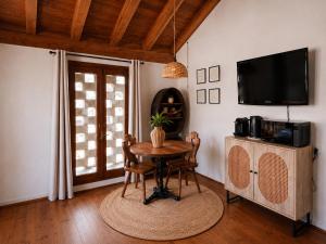 a dining room with a table and a tv at Ca' Bastiàn in Sacco