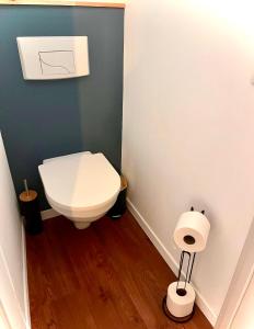 a bathroom with a toilet and a toilet paper dispenser at Suite Église in Veynes +3 photos
