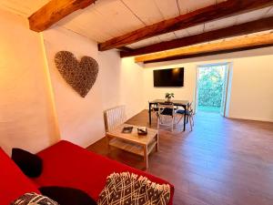 a living room with a red couch and a table at Suite Église in Veynes