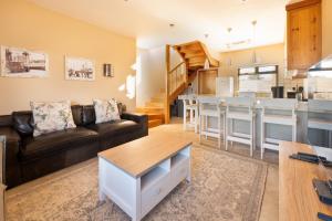 a living room with a couch and a kitchen at Lagoon View Self Catering in Walvis Bay