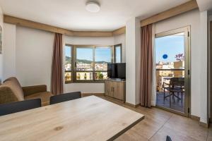a living room with a table and a television at Marina Beach Apartaments - Sea views in the heart of Lloret in Lloret de Mar