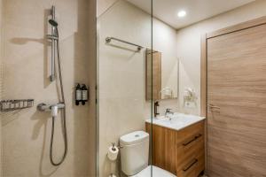 a bathroom with a shower and a toilet and a sink at Marina Beach Apartaments - Sea views in the heart of Lloret in Lloret de Mar +51 photos