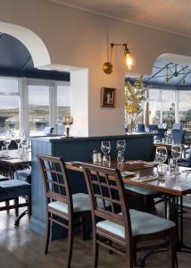 a dining room with tables and chairs and windows at The Smugglers Inn in Waterville