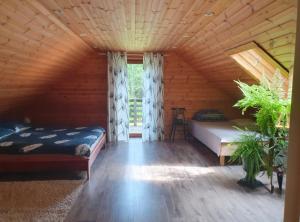 a bedroom with two beds in a log cabin at Väike-Puusmetsa puhkemaja in Valtina