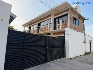 a house with a black gate in front of a building at Villas La Vista in Tuxpan de Rodríguez Cano