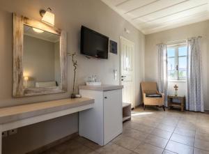a bathroom with a mirror and a tv on the wall at Almyris in Adamantas +63 photos