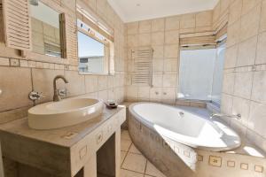 a bathroom with a large tub and a sink at Lagoon View Self Catering in Walvis Bay +49 photos