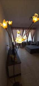a vase with yellow flowers in a living room at Mista apartment in Peyia