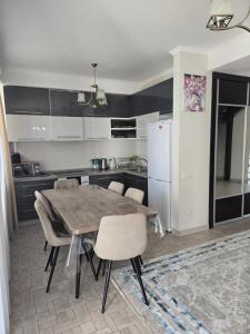 a kitchen with a table and chairs and a refrigerator at Baytur-Yilla09 in Bosteri