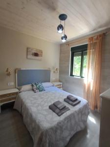 a bedroom with a bed with two towels on it at O LAR DO SIL - Ribeira Sacra in Villar de Cerreda