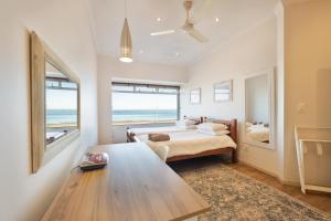 a bedroom with a table and a bed with a view of the ocean at Lagoon View Self Catering in Walvis Bay