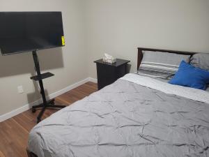 a bedroom with a bed and a flat screen tv at Private 2 bedroom suite close to everything! in Maple Ridge