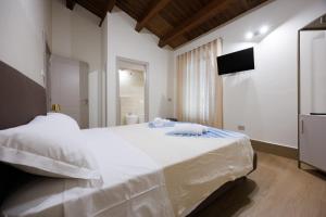 a bedroom with a large white bed and a television at B&B Alba in Celano