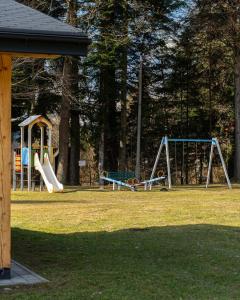 a park with two swings and a playground at Górski Ośrodek Pod Kamiennikiem in Poręba
