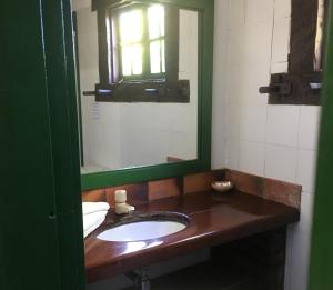 a bathroom with a sink and a mirror at Barla Inn Suites in Búzios +6 photos