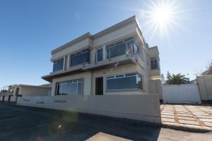 a house with the sun in the sky at Lagoon View Self Catering in Walvis Bay
