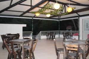 a patio with wooden tables and chairs and lights at Finca Campestre el Paraíso Resort Hotel en Mesitas in El Colegio