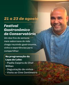a man is standing next to a pizza at Pousada e Adega Lapa do Lobo in Conservatória