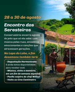 a poster for an event with a man standing next to a bench at Pousada e Adega Lapa do Lobo in Conservatória