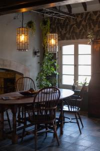 a dining room with a table and chairs and a fireplace at Maison Bienvenue in Lierop