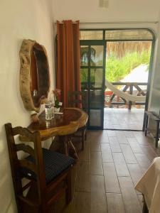 a dining room with a table and a mirror on the wall at Villa del Mar in Zipolite