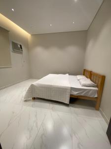 a bedroom with a bed in a white room at الضاحية 