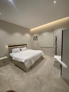 a bedroom with a white bed and a white screen at الضاحية 