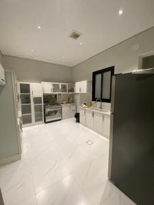 a large kitchen with a large white tile floor at الضاحية 