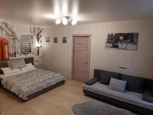 a bedroom with a bed and a couch in it at Luxuri apartments in Chernihiv