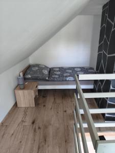 a small room with a bed and a wooden floor at Chata Rumunka in Jaroměř