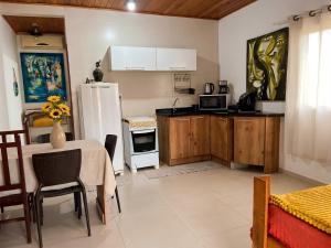 a kitchen with a table and a white refrigerator at Pousada Canto Gira Sol Penha SC Estúdio Sol 5 Min do Beto Carrero in Penha