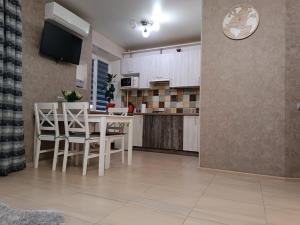 a kitchen and dining room with a table and chairs at Luxuri apartments in Chernihiv