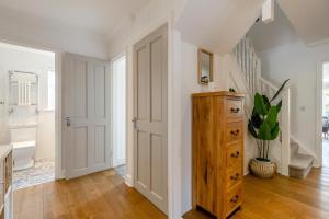 a white hallway with a wooden cabinet and a bathroom at 5 Bed in Bodham oc-2204 in Bodham +52 photos